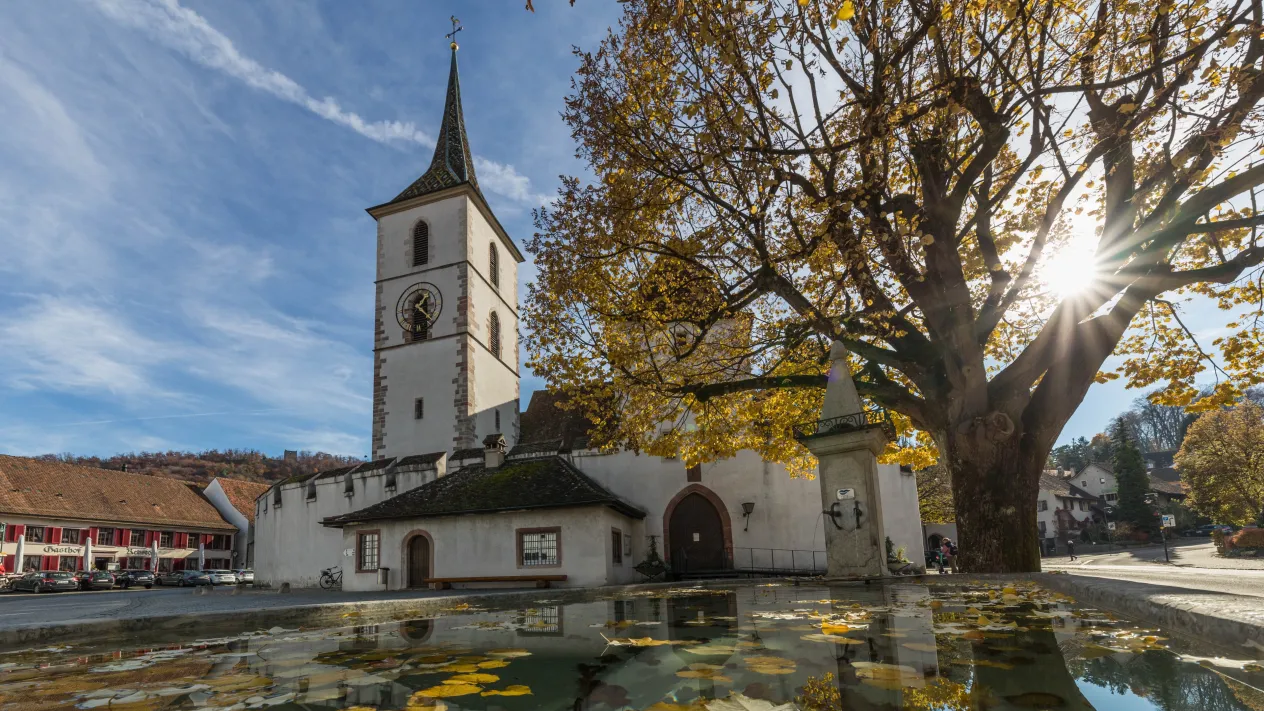 Herbstsonne auf dem Kirchplatz (Foto: Peter Wehrli) &mdash; Dorfkirche mit Dorfbrunnen Herbst