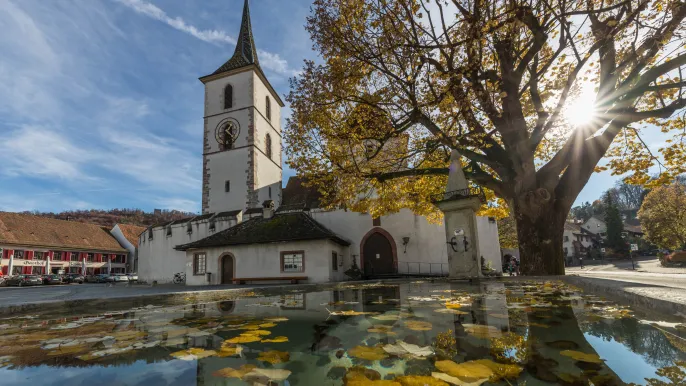 Herbstsonne auf dem Kirchplatz: Dorfkirche mit Dorfbrunnen Herbst (Foto: Peter Wehrli)