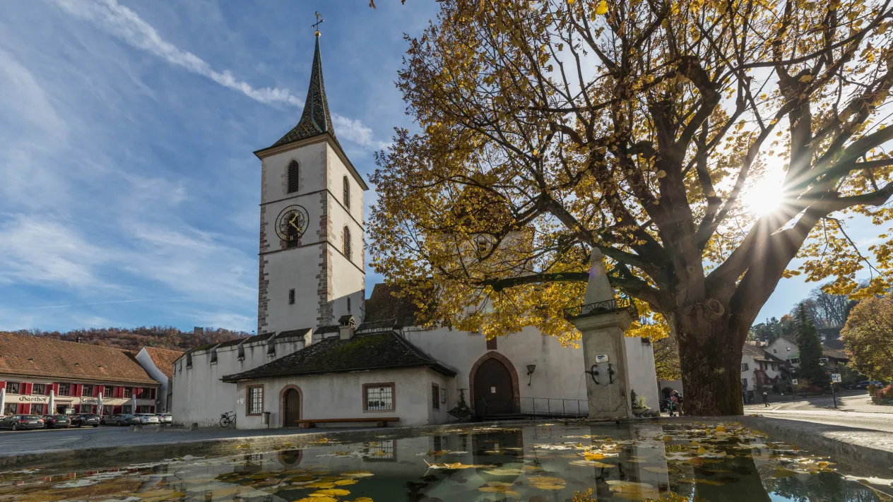 Herbstsonne auf dem Kirchplatz &mdash; Dorfkirche mit Dorfbrunnen Herbst (Foto: Peter Wehrli)